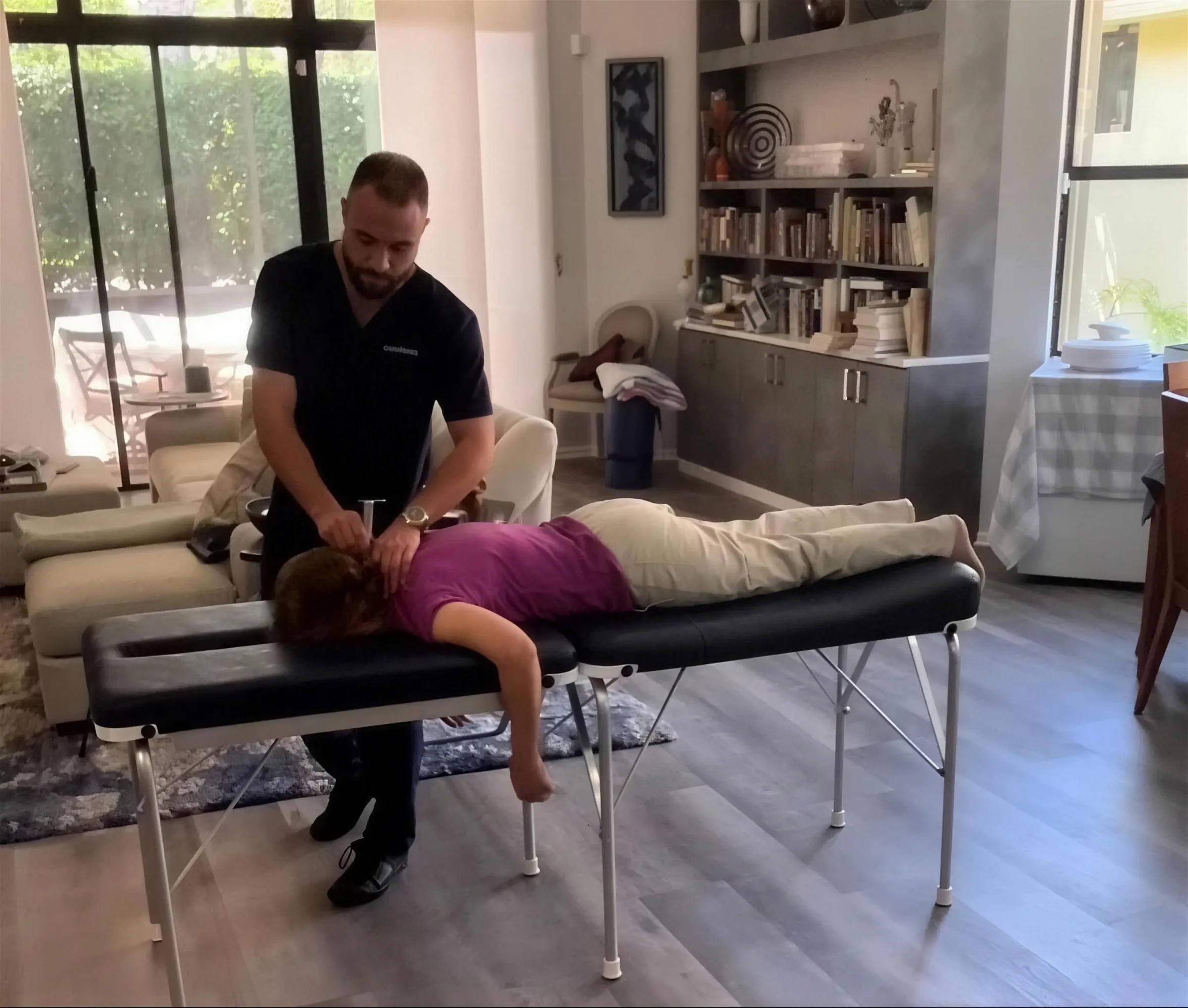 Dr. Yale Gordon delivering an instrument adjustment on a portable table in a patient's living room